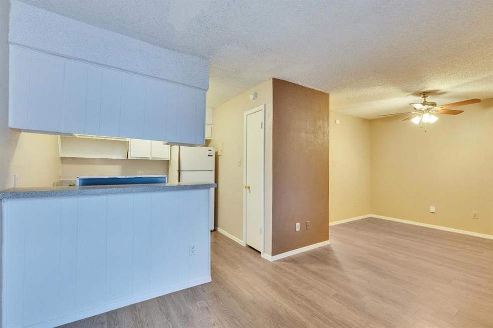 Kitchen with a peninsula, a textured ceiling, bas