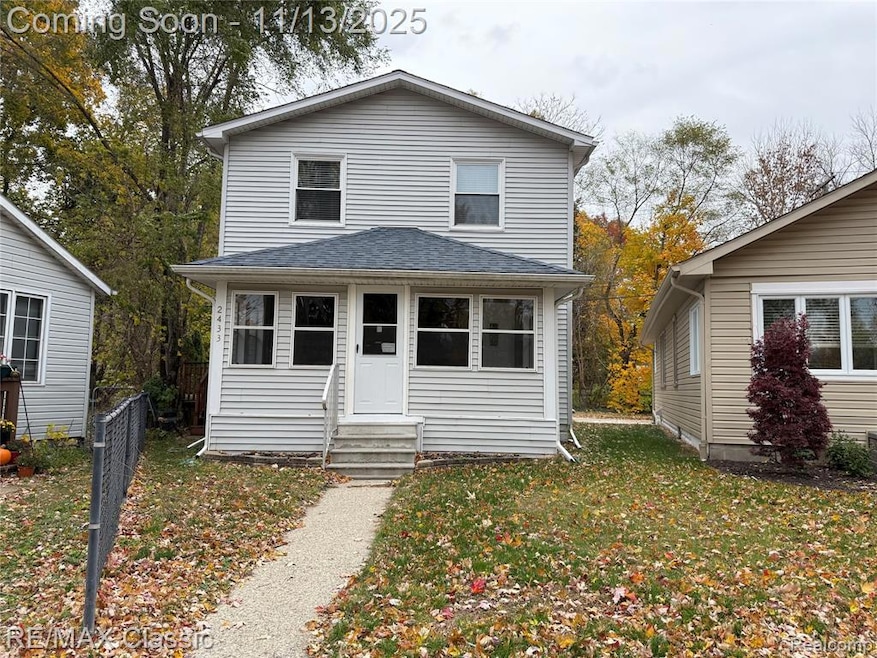 View of front of house featuring entry steps, a sunroom, front lawn, and newer roof