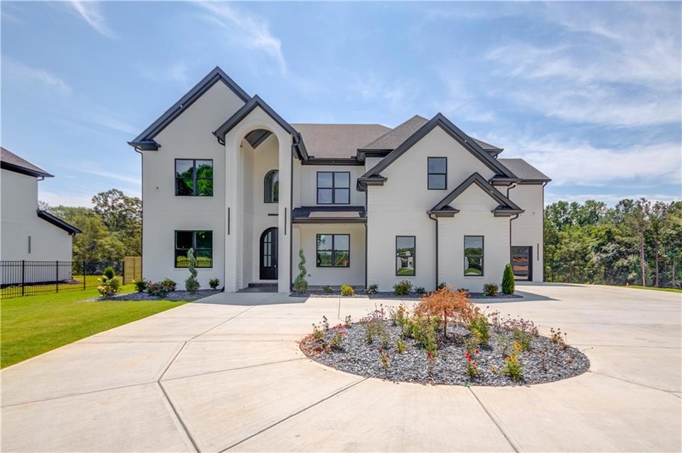 View of front of house with curved driveway and stucco siding