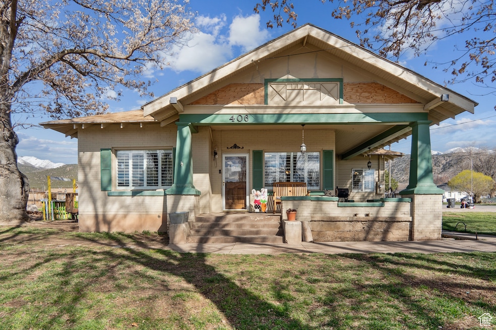 Rear view of property with a lawn, covered porch, and a mountain view