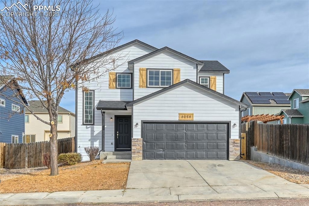 Traditional-style home with stone siding, concrete driveway, and a garage