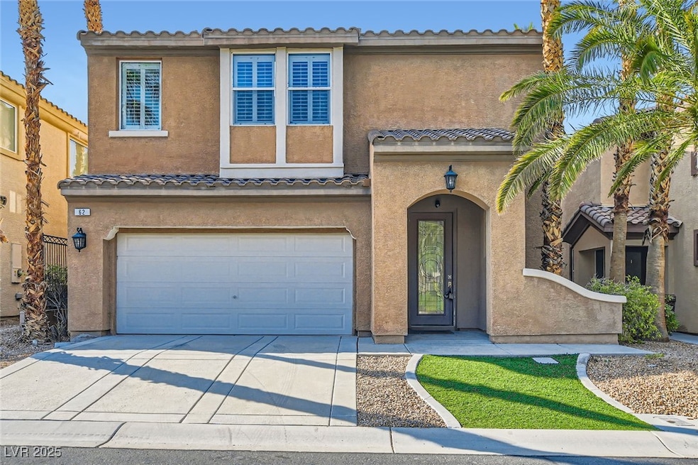 View of front of property with a garage, stucco si