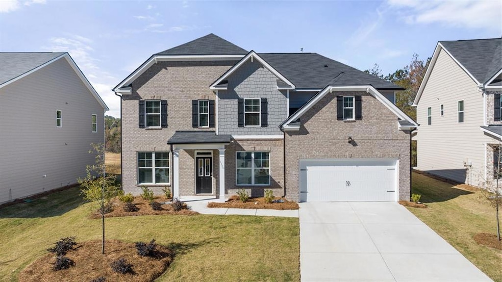 View of front of home with a garage and a front ya