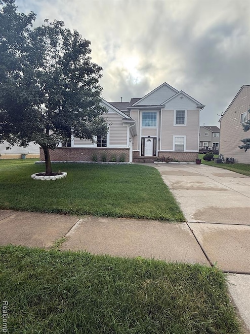 View of front of house with brick siding and a front lawn