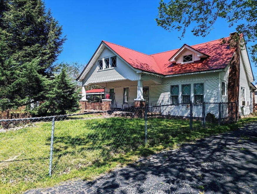 Front house with chain linked fence, carport