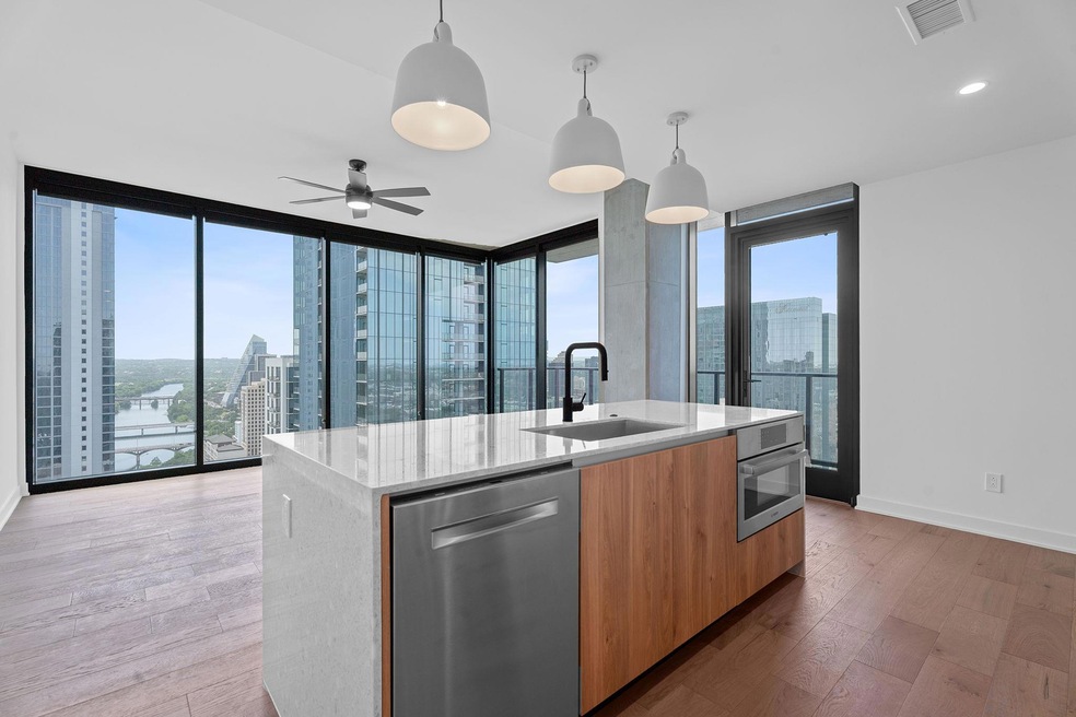 Kitchen featuring stainless steel appliances, modern cabinets, a kitchen island with sink, and a view of city