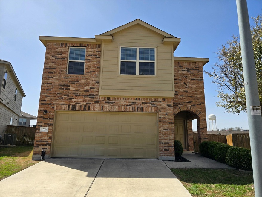 View of front of property featuring brick siding, driveway, and an attached garage