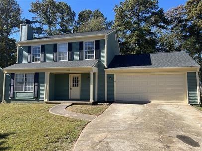View of front of home with a front yard and a gara