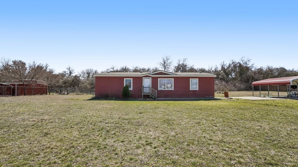 View of front of house with fence and a front lawn