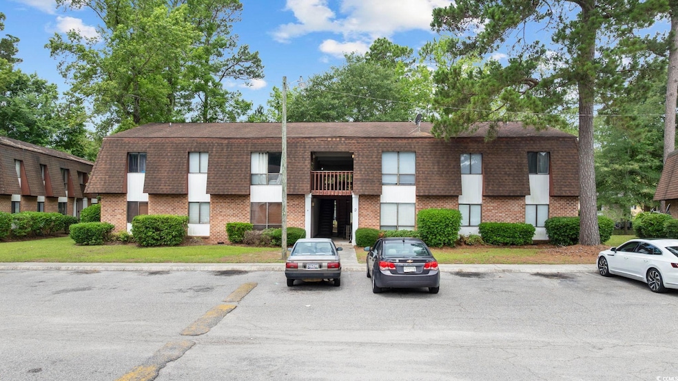 View of building exterior with uncovered parking