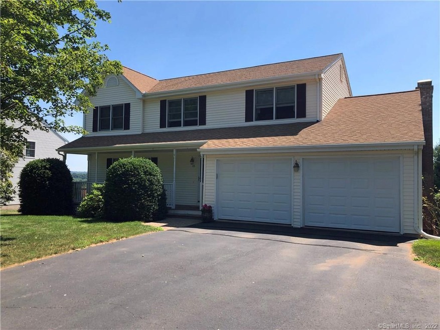 Front of home with large driveway and two car atta