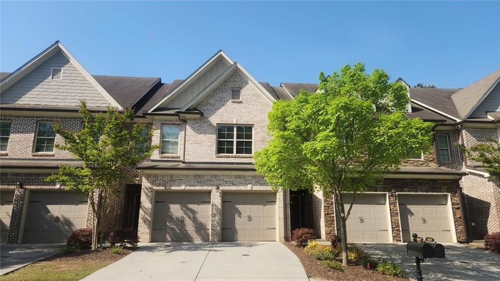 View of front facade featuring driveway, brick sid