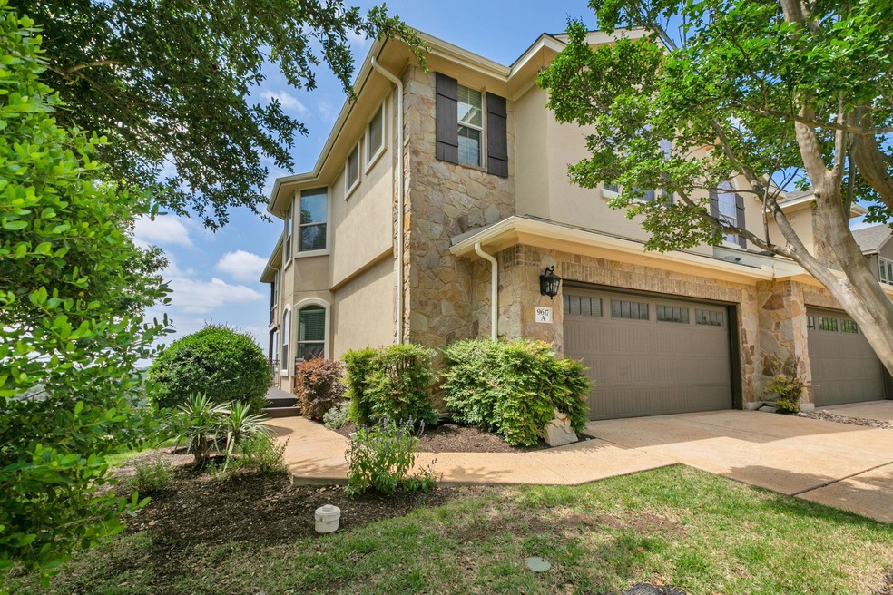 View of property with stone siding, an attached g