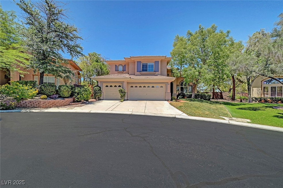 View of front of home with stucco siding, a front lawn, driveway, and an attached garage