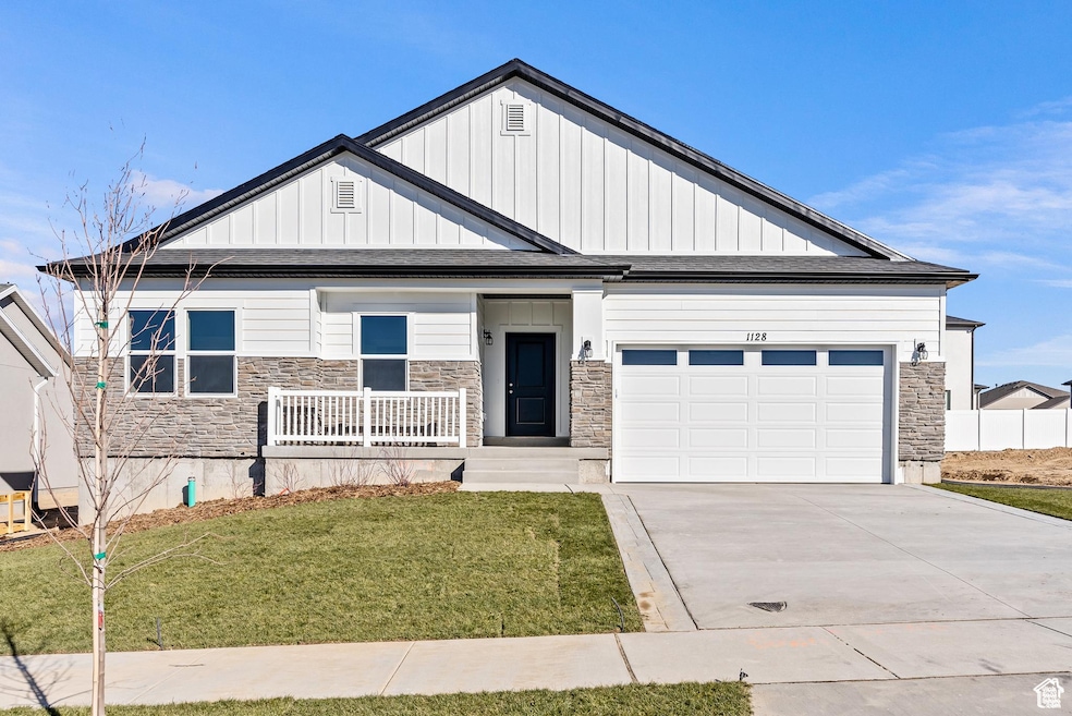 Craftsman-style home with stone siding, board and batten siding, and driveway