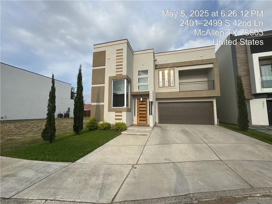 Modern home featuring stucco siding, a garage, and driveway