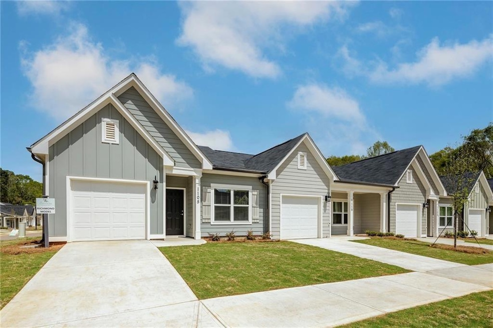View of front of property featuring board and batten siding, driveway, a front yard, and an attached garage