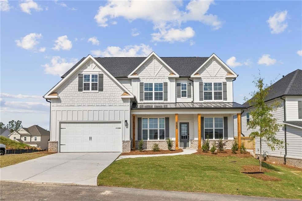 Craftsman inspired home featuring board and batten siding, a porch, driveway, a front lawn, and a metal roof