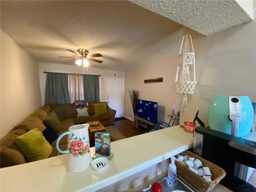 Living room featuring ceiling fan and a textured c