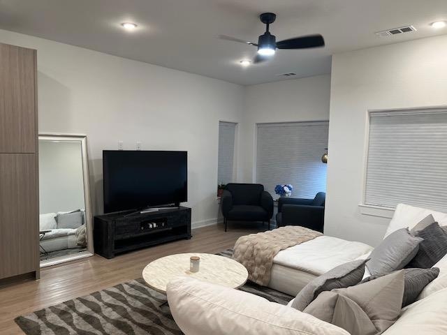 Living room featuring a ceiling fan and wood fini
