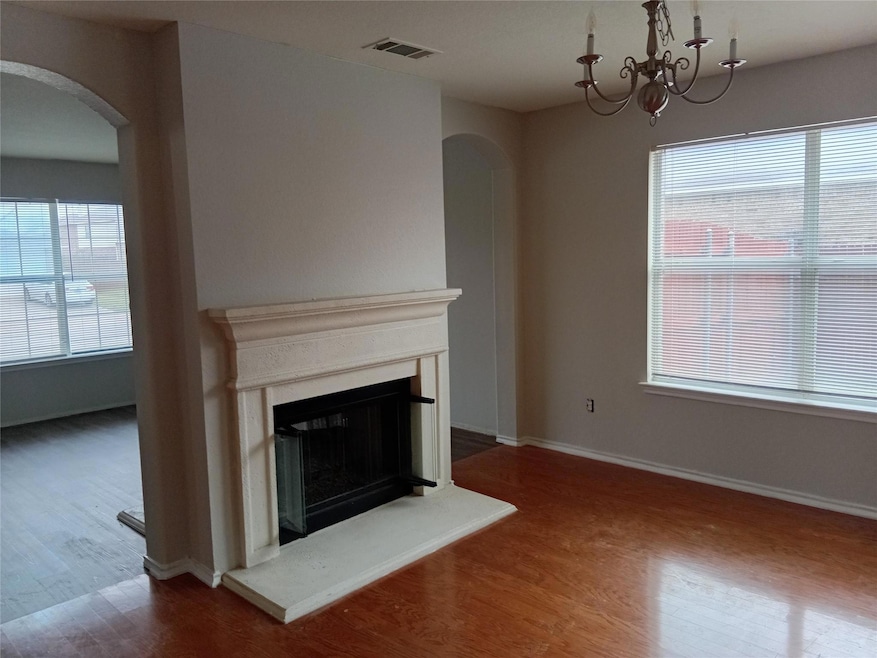Unfurnished living room with visible vents, arched