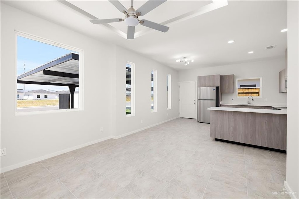 Kitchen with modern cabinets, freestanding refrigerator, plenty of natural light, light countertops, and recessed lighting