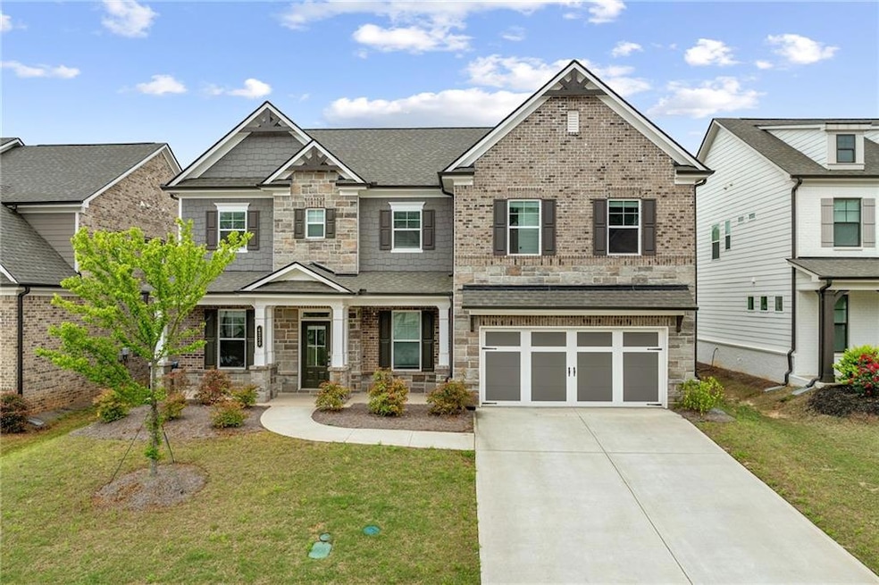 Craftsman house with a garage, driveway, stone sid