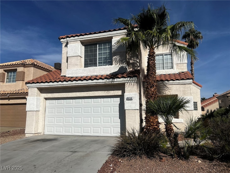 Mediterranean / spanish house with concrete driveway, stucco siding, an attached garage, and a tile roof