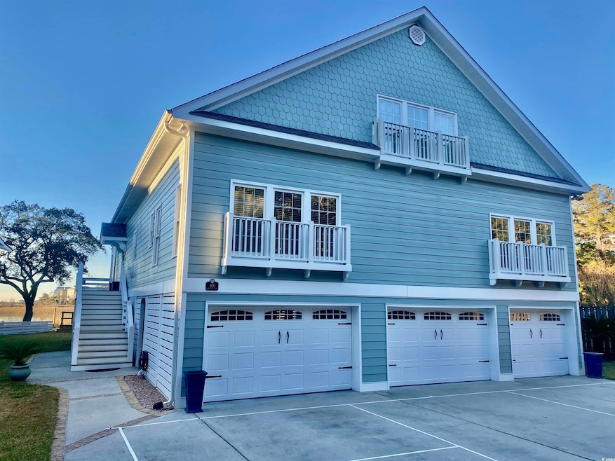 View of side of property with a garage and a balco