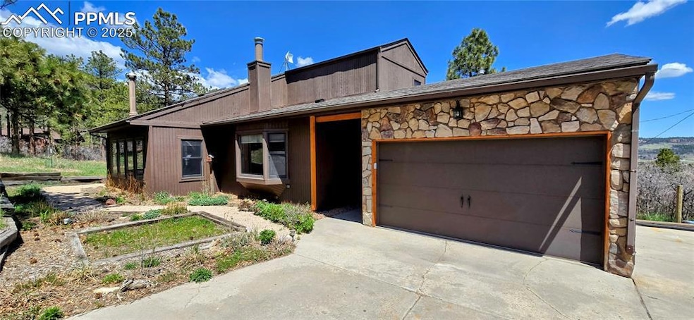 View of front of property with stone siding, a gar