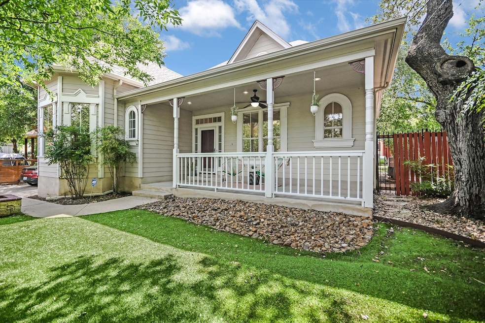 Rear view of house featuring a ceiling fan and covered porch