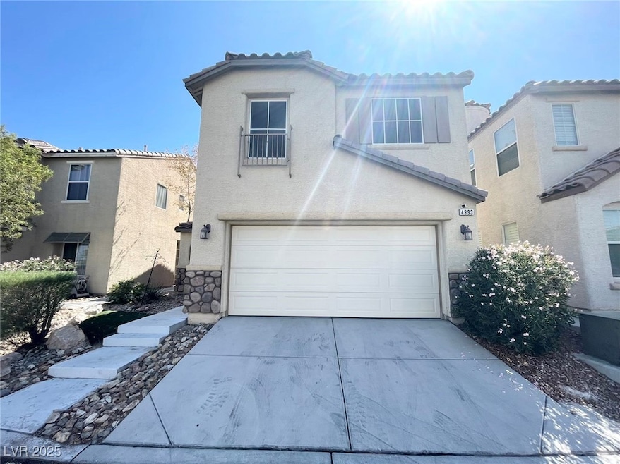 View of front of home with driveway, stucco siding, a garage, a tiled roof, and stone siding