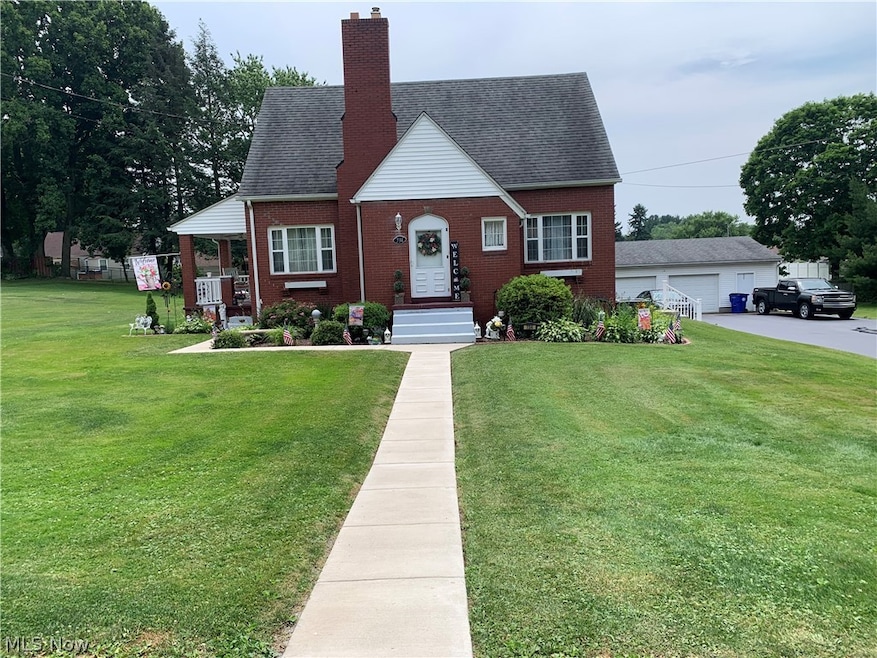 View of front facade featuring a garage, an outdoor structure, and a front​​‌​​​​‌​​‌‌​​​‌​​‌‌​​‌‌​‌​​​‌‌​​‌​​​​​‌ yard