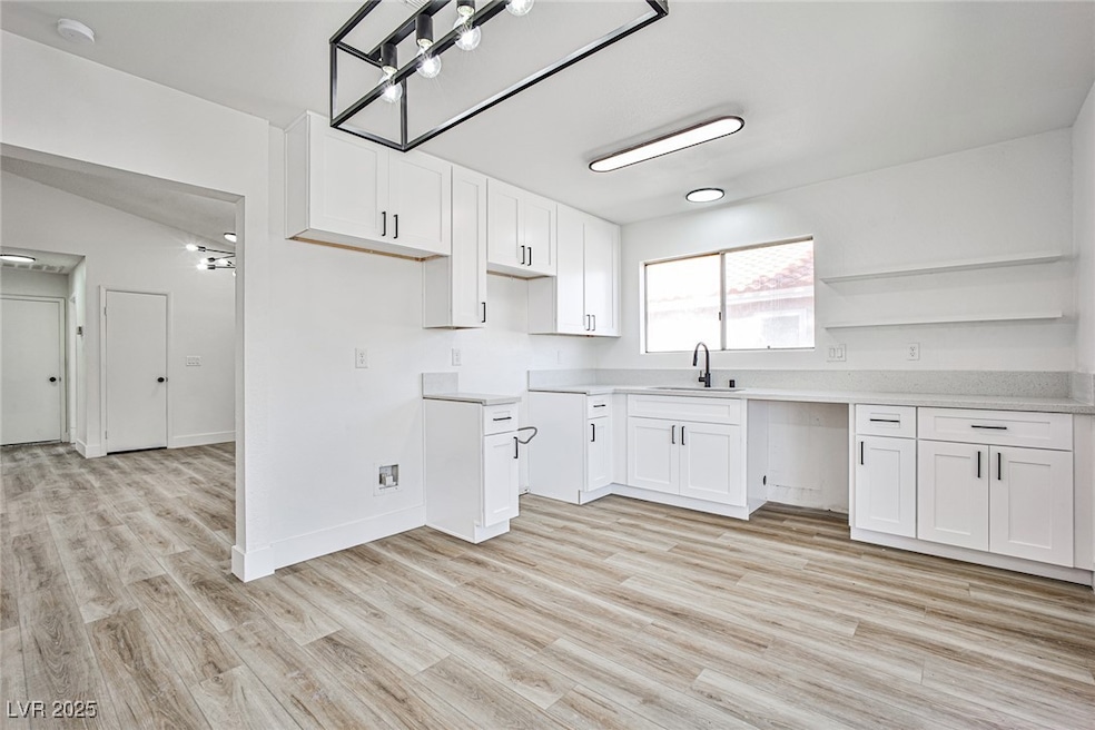 Kitchen with white cabinetry and light wood-type flooring