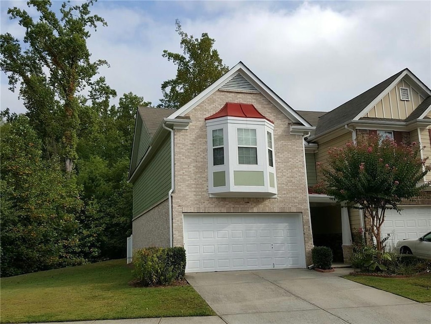 View of front of home featuring driveway, an attac