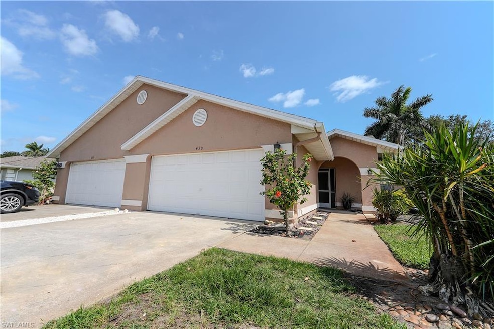 View of front facade featuring stucco siding, an attached garage, and driveway