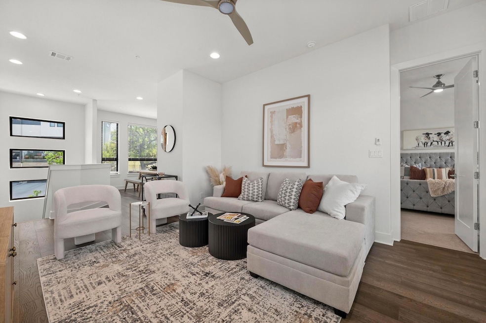 Living room featuring visible vents, ceiling fan,