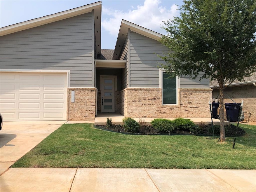 View of front of house with a garage and a front y