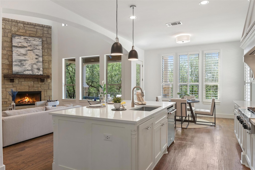 Kitchen with a fireplace, white cabinets, stainle