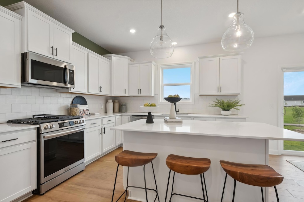 (Photos of model home, features will vary) This stylish kitchen showcases a large center island, Shaker-style cabinetry, and brand-new stainless-steel appliances.