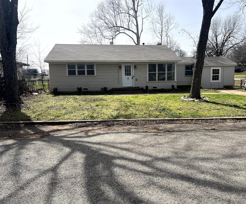 Ranch-style house with entry steps, fence, and a f