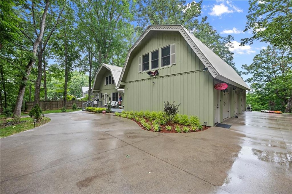 View of side of home featuring a gambrel roof and driveway
