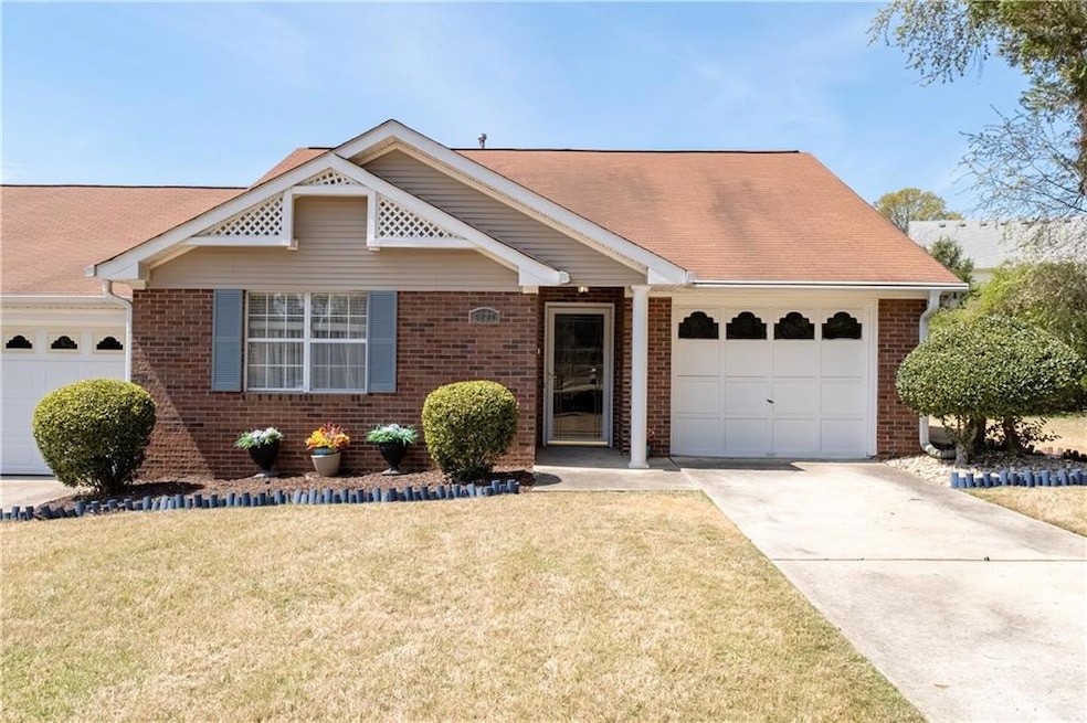 View of front of home featuring brick siding, a ga