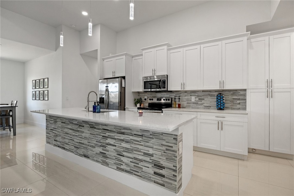 Kitchen featuring a sink, white cabinetry, decorat