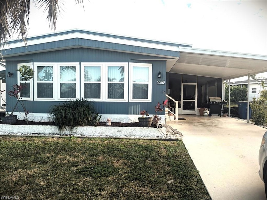 Rear view of property featuring a carport, concret