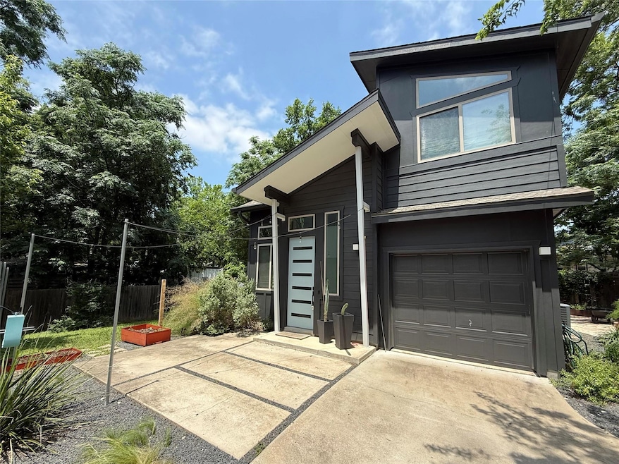 View of front of property with fence, a garage, a