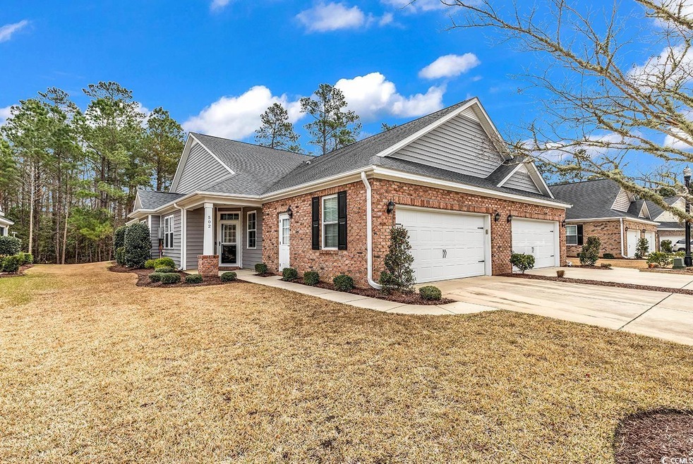 View of front of home featuring roof with shingles, concrete driveway, a front lawn, a garage, and brick siding