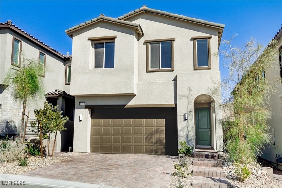 decorative driveway, an attached garage, and stucc