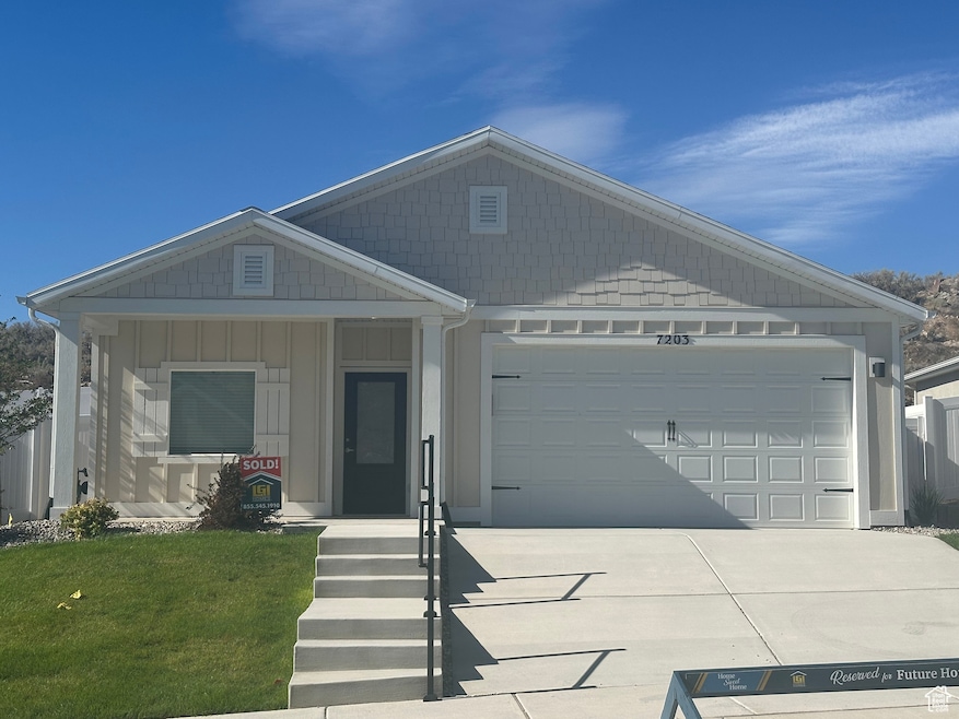 View of front facade featuring driveway, an attached garage, and a porch
