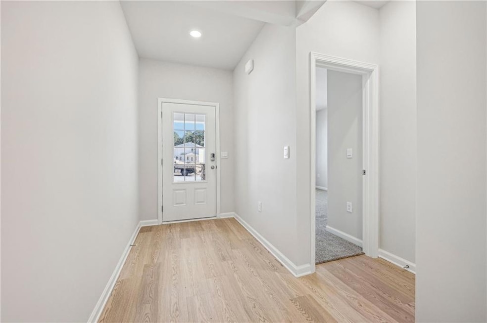 Doorway with light wood-style floors and recessed lighting